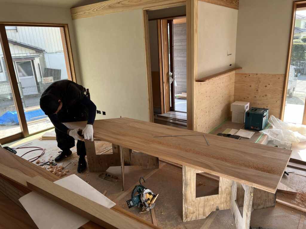 職人が手作業で無垢天板を加工する造作キッチンの施工風景